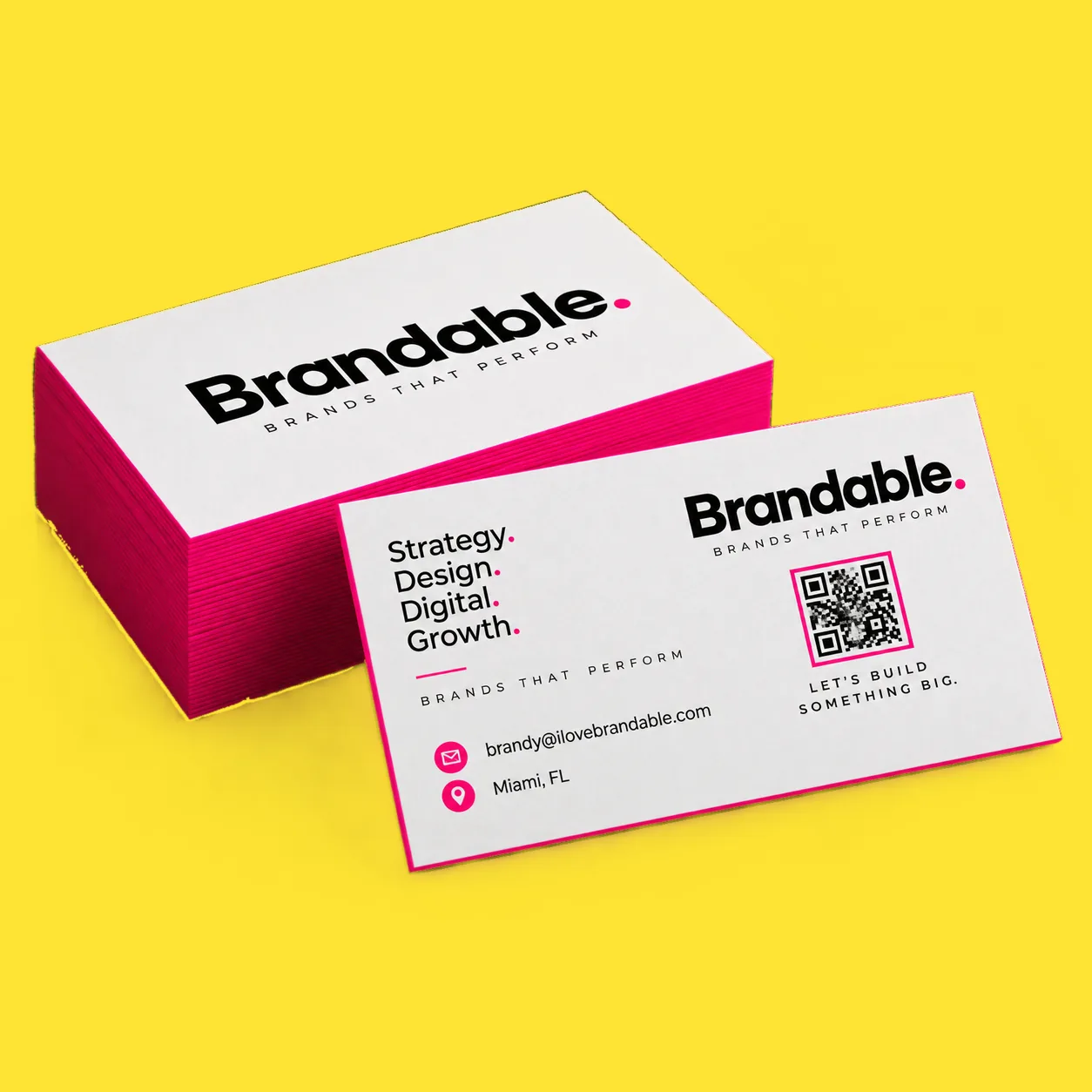 Business cards with a hot pink painted edge on a yellow ground